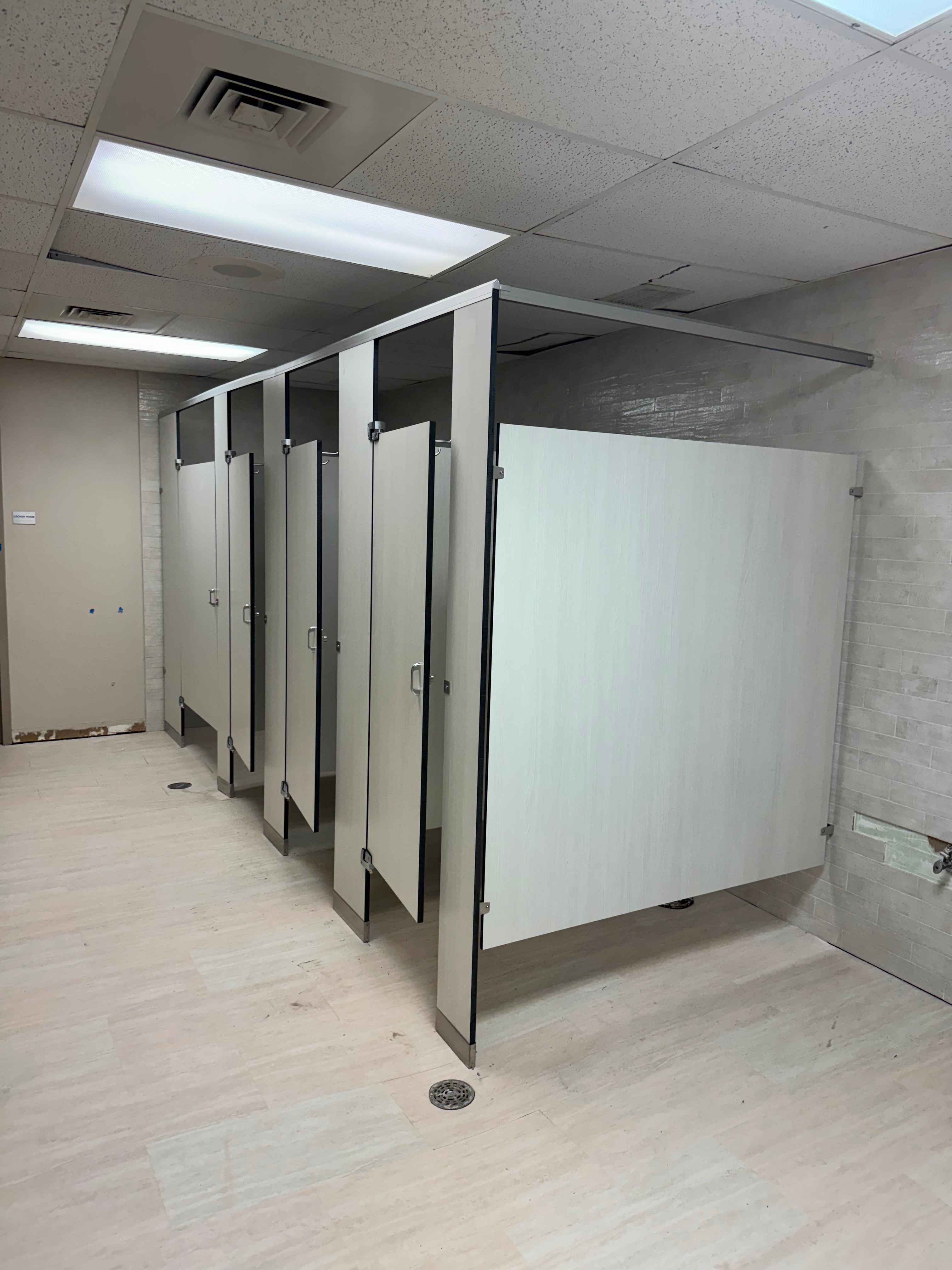 Light gray black core phenolic bathroom partitions at an academy remodel in Fort Worth, Texas
