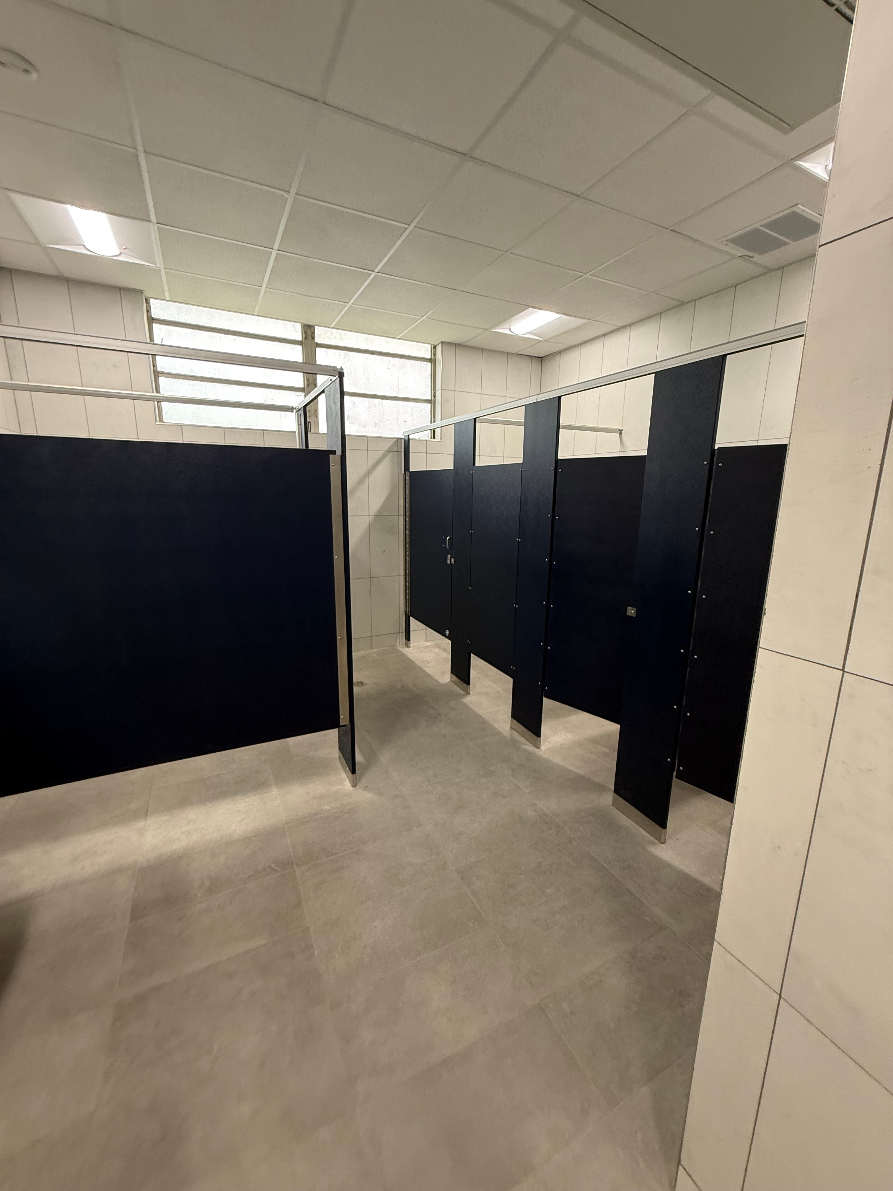Navy blue solid plastic HDPE bathroom partitions in an elementary school in West Monroe, Louisiana
